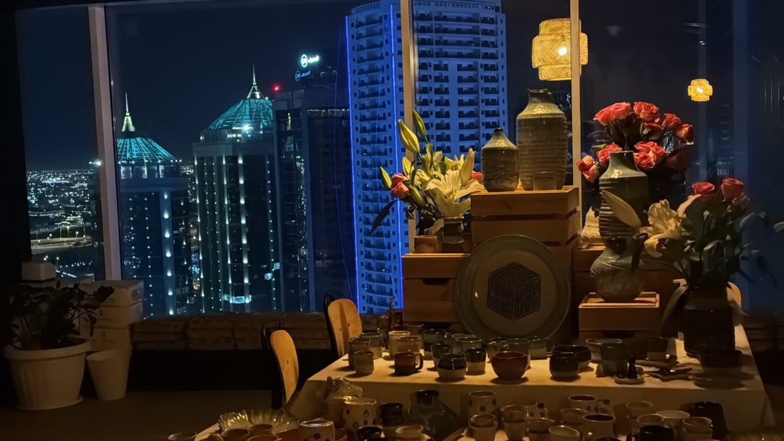 Handmade pottery displayed against the Doha night skyline at Ceramic Cube pottery studio, 30th floor Excellence Tower, West Bay